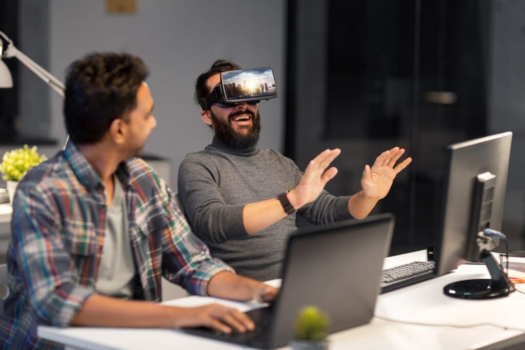 two young architects working, one ith virtual reality glasses on - used to illustrate how the architects can give virtual tours of thheir projects